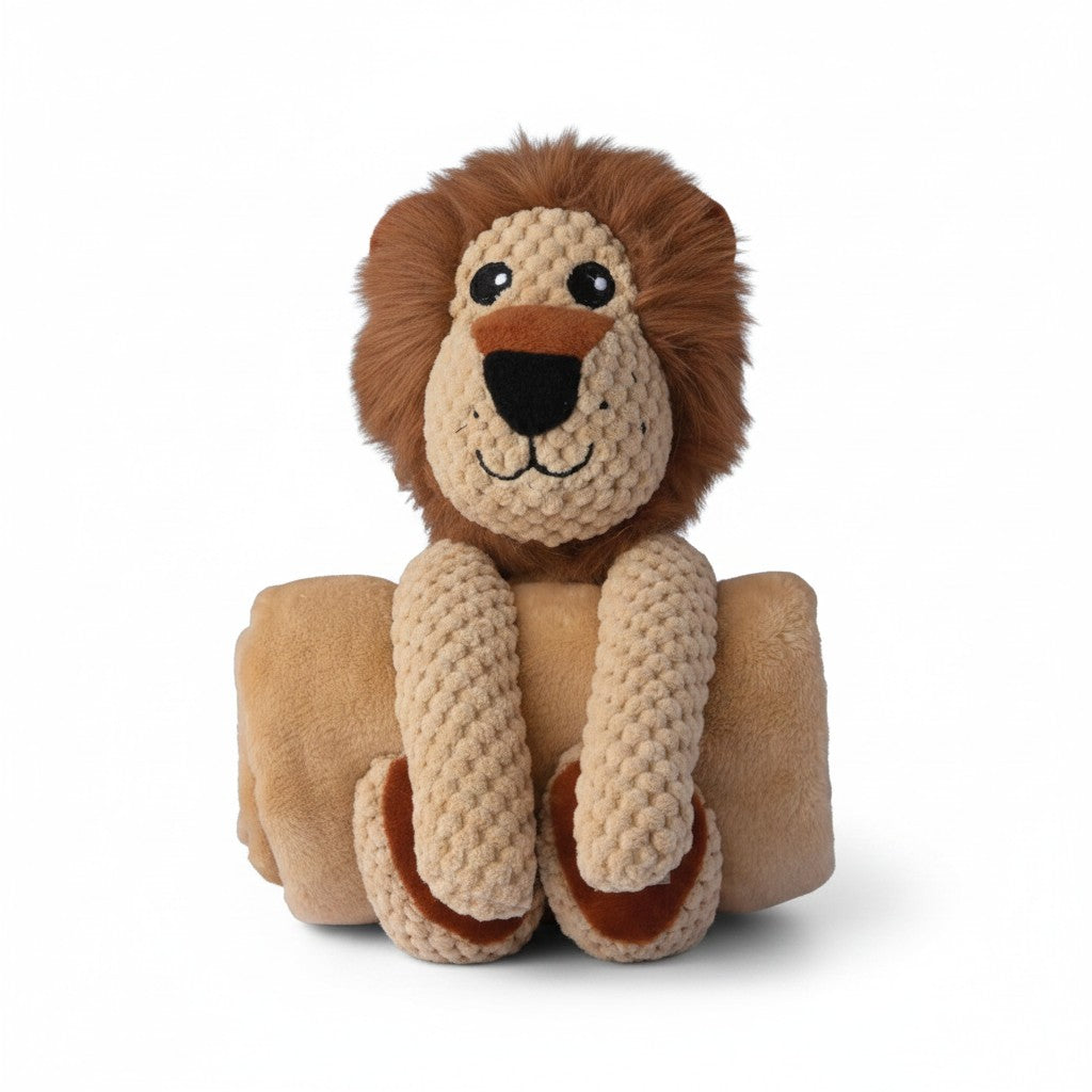  Une peluche pour chien représentant un lion beige à crinière marron, maintenant une couverture polaire beige enroulée sous ses pattes.