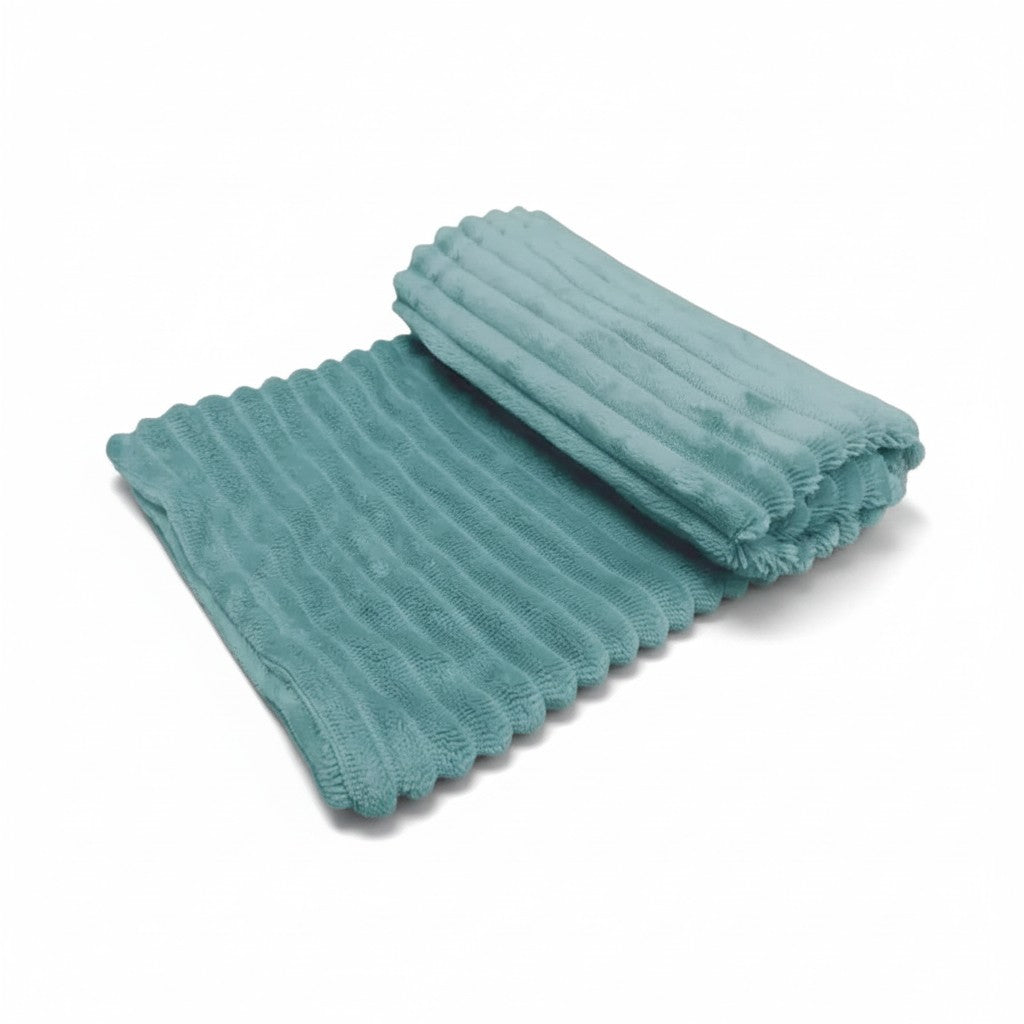 Couverture pour chien et chat en tissu ultra-doux de couleur bleu aqua, en partie roulée, laissant apparaître un relief cannelé effet velours côtelé sur fond blanc uni.
