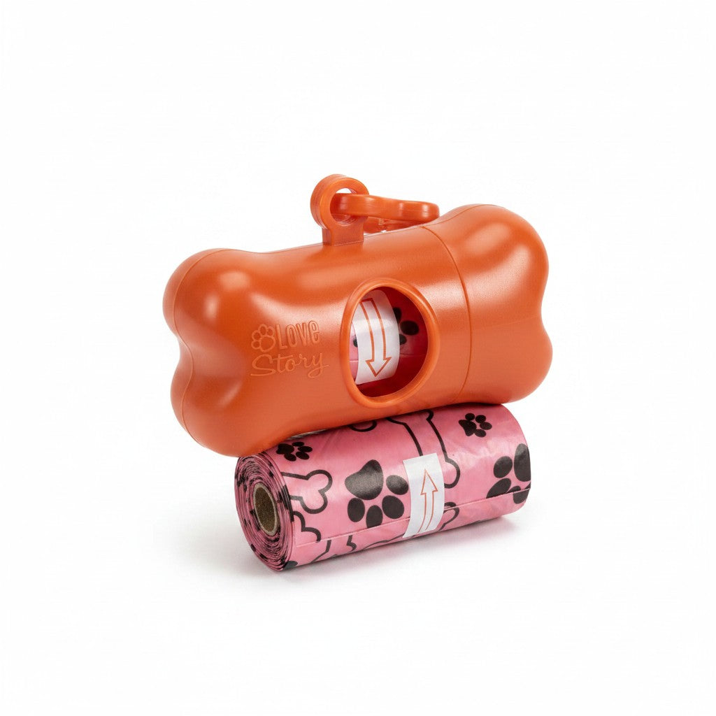 Distributeur de sacs à crottes rouge en forme d'os avec logo Love Story et clip d'attache, posé sur un rouleau de sacs hygiéniques rouges à motifs de pattes de chien.