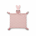 Doudou plat pour chien en forme de lapin rose pastel. Le corps en tissu présente de petits motifs imprimés de carottes oranges. La tête en peluche rembourrée surmonte le doudou, et les quatre coins se terminent par des nœuds en corde tressée blanc et rose.