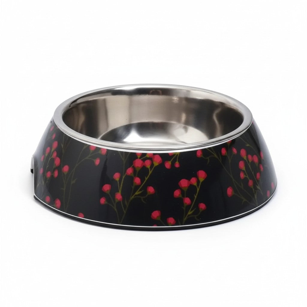 Une gamelle pour chien évasée en mélamine noire, décorée de fines branches vertes et de petits bourgeons de fleurs roses style hanami. L'intérieur comprend un bol amovible en acier inoxydable brillant.