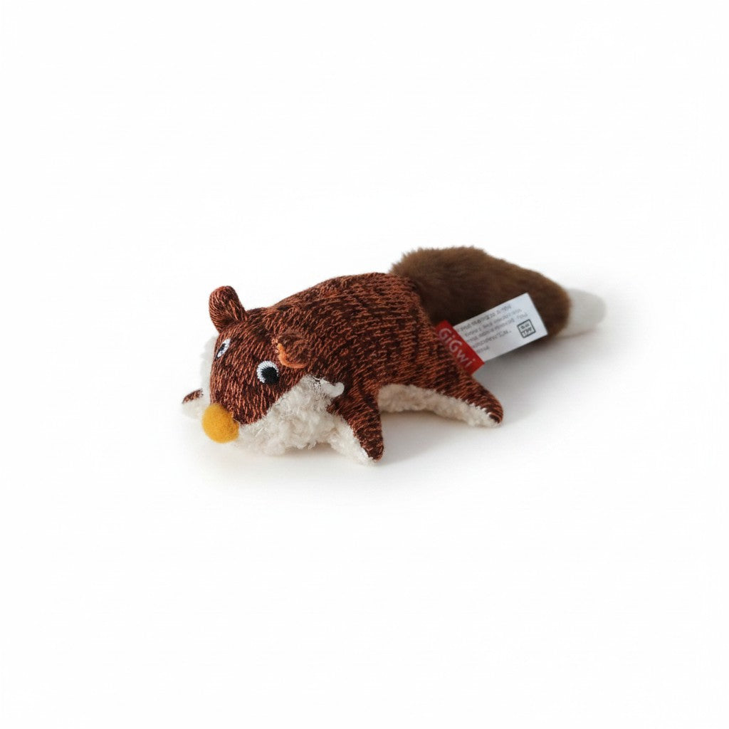Peluche pour chien en forme de petit  renard marron et blanc, allongé à plat de profil sur fond blanc. Le corps présente un tissu texturé marron à l'aspect tricoté, un ventre en fausse fourrure blanche bouclée et un petit nez orange en relief. Une longue queue touffue marron à pointe blanche s'étire à l'arrière, surmontée d'une étiquette rouge de la marque GiGwi.