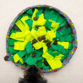 Tapis de fouille garni de friandises brunes cachées entre les lanières vertes et jaunes, museau d'un chien noir approchant pour renifler