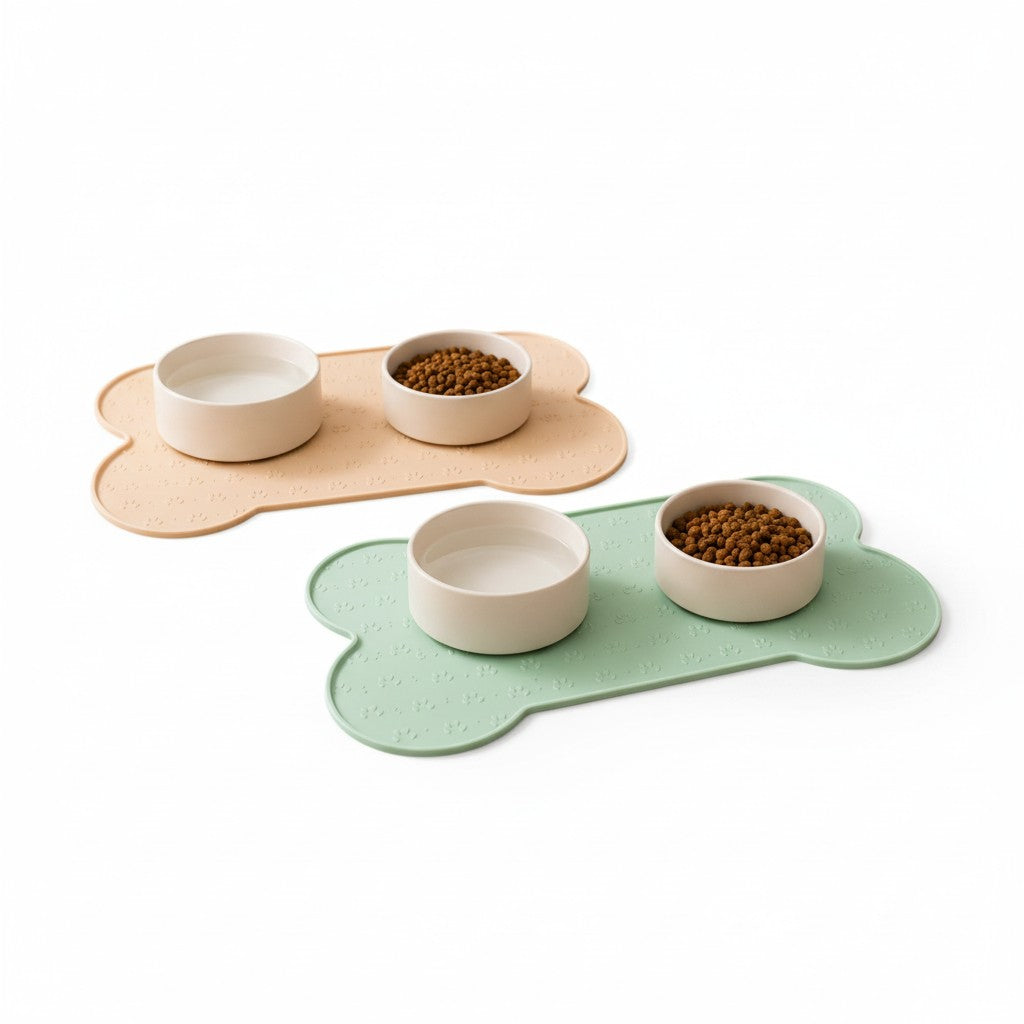 Deux tapis de gamelle antidérapants en silicone forme os beige et vert menthe avec deux bols blancs croquettes et eau pour chien